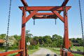 Rode ophaalbrug met kettingen en weg onder blauwe lucht