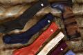 Lange wollen kousen in groen, blauw, oranje, crème en bordeaux naast een laars