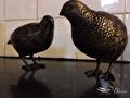 Twee bronzen kwartels voor een witte tegelwand