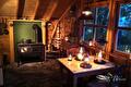Gezellige kamer met houtkachel en brandende windlichten op tafel