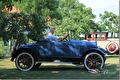 Blauwe open oldtimer met bestuurder in de tuin
