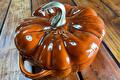 Oranje gietijzeren Staub pompoenpan met messing knop op hout