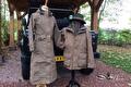 Twee lange beige jassen op paspoppen voor een terreinwagen