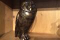 Staande bronzen uil in een houten vak