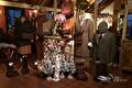 Winkelinterieur met tweed jassen, kerstboompjes en lichtjes