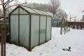Tuinkas met matglas in een besneeuwde tuin